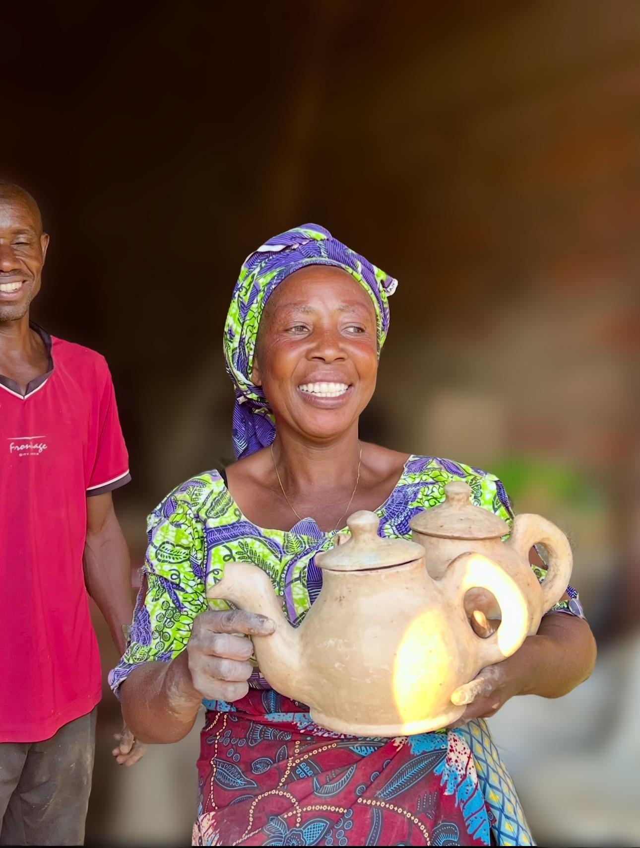 Smiling African artisan holding a handcrafted clay pot, showcasing traditional pottery craftsmanship