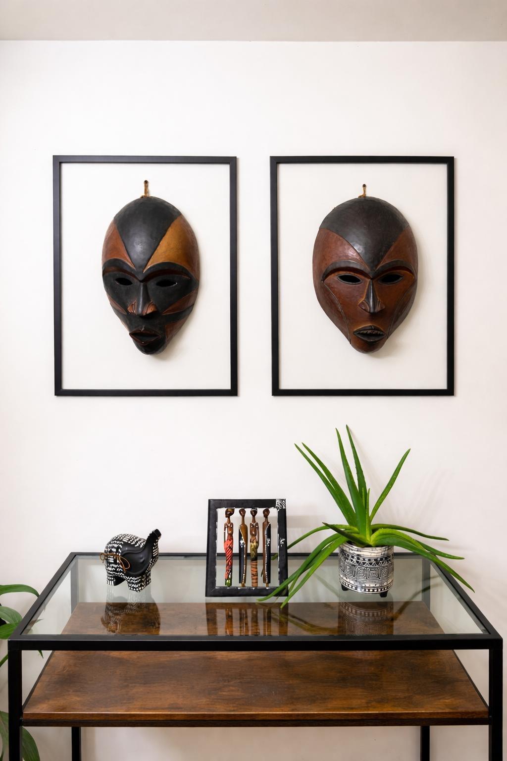 Hand-carved African masks displayed on a wall in a styled modern British home interior